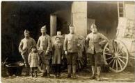1 vue Groupe de 4 soldats de la 307e R.I., avec des enfants et, en arrière plan, une cuisine roulante.